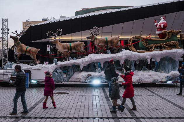 People walk by a Santa Claus statue in the Quartier des Spectacles on Christmas Day in Montreal. Pedestrians took some time to enjoy the Christmas cheer as the province goes into another lockdown period that is meant to last at least three weeks. (AP Photo/Andrej Ivanov) People walk by a Santa Claus statue in the Quartier des Spectacles on Christmas Day in Montreal. Pedestrians took some time to enjoy the Christmas cheer as the province goes into another lockdown period that is meant to last at least three weeks. (AP Photo/Andrej Ivanov)
