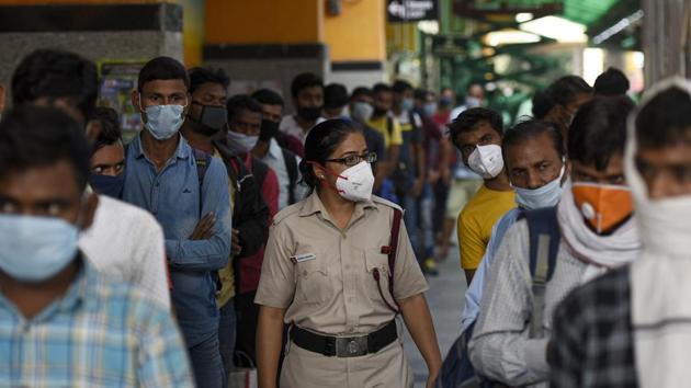 A police official checks the passengers waiting in line to give samples for coronavirus rapid antigen test after arriving at Hazrat Nizamuddin Railway Station, in New Delhi.(Biplov Bhuyan/HT PHOTO) A police official checks the passengers waiting in line to give samples for coronavirus rapid antigen test after arriving at Hazrat Nizamuddin Railway Station, in New Delhi.(Biplov Bhuyan/HT PHOTO)