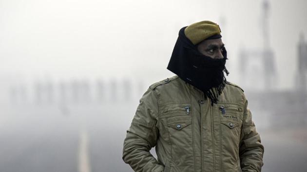 A police personnel seen on a foggy morning near India Gate in New Delhi, India.(Biplov Bhuyan/HT PHOTO)