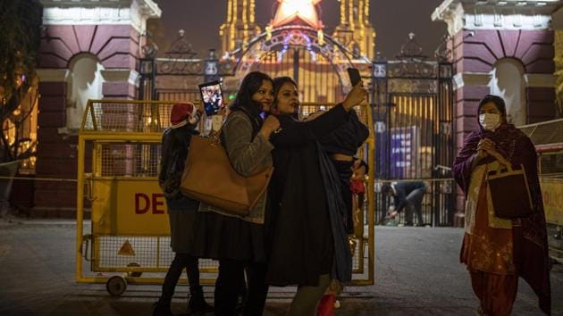 Indian women take a selfie outside Sacred Hearth Cathedral which is closed to general public due to Covid-19 restrictions on the eve of Christmas in New Delhi, India. (AP) Indian women take a selfie outside Sacred Hearth Cathedral which is closed to general public due to Covid-19 restrictions on the eve of Christmas in New Delhi, India. (AP)
