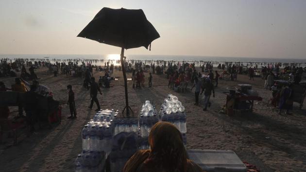 A woman sells packed drinking water at a crowded Juhu beach in Mumbai on December 26. India’s current case count from the viral disease is at 10,187,850 with 147,659 cumulative deaths so far. The case fatality rate currently rests at 1.45%. (Rafiq Maqbool / AP) A woman sells packed drinking water at a crowded Juhu beach in Mumbai on December 26. India’s current case count from the viral disease is at 10,187,850 with 147,659 cumulative deaths so far. The case fatality rate currently rests at 1.45%. (Rafiq Maqbool / AP)