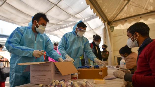 Healthcare workers with the swab samples collected for Covid-19 test at Anand Vihar Bus Terminal in New Delhi on Saturday. (Sanchit Khanna/HT Photo) Healthcare workers with the swab samples collected for Covid-19 test at Anand Vihar Bus Terminal in New Delhi on Saturday. (Sanchit Khanna/HT Photo)