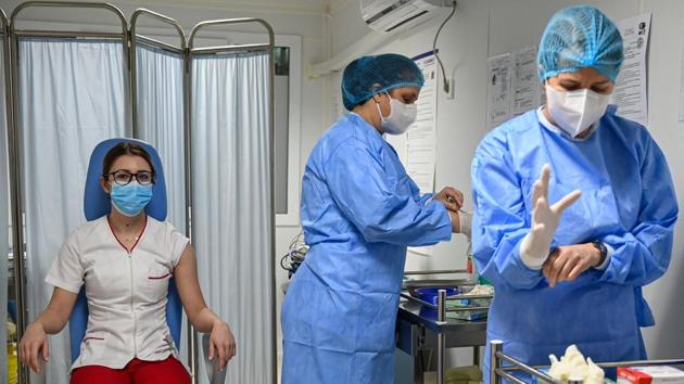 Medical workers prepare a dose of the Pfizer-BioNTech Covid-19 vaccine for a nurse at the infectious diseases hospital "Matei Bals", in Bucharest, Romania on December 27. The numbers of those vaccinated in the initial days are largely symbolic and it will be months before enough are protected to envisage a return to normal from the pandemic that has killed 1.76 million people worldwide. (Daniel Mihailescu / Pool / AFP)