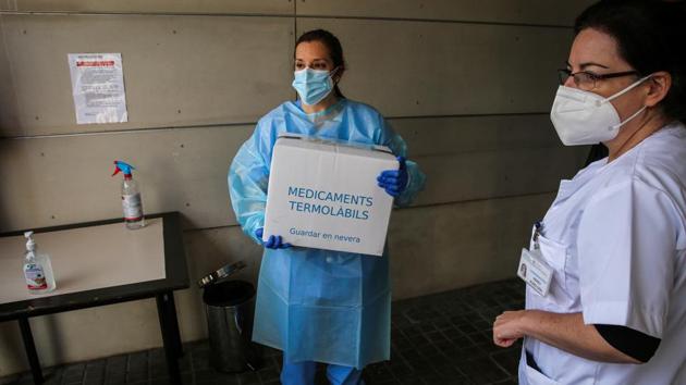 A nurse carries a box containing the Pfizer-BioNTech Covid-19 vaccine at the Feixa Llarga nursing home, in Barcelona, Spain. An unprecedented continent-wide vaccination campaign was underway in Europe, with Italy, Germany, Austria, France and the Nordics all launching their vaccination programs, less than a week after the EU cleared a shot developed by Pfizer Inc. and BioNTech SE.(Bloomberg) A nurse carries a box containing the Pfizer-BioNTech Covid-19 vaccine at the Feixa Llarga nursing home, in Barcelona, Spain. An unprecedented continent-wide vaccination campaign was underway in Europe, with Italy, Germany, Austria, France and the Nordics all launching their vaccination programs, less than a week after the EU cleared a shot developed by Pfizer Inc. and BioNTech SE.(Bloomberg)
