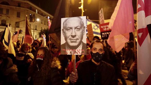 Israeli protesters hold signs during a demonstration against Israeli Prime Minister Benjamin Netanyahu in Jerusalem.(AP) Israeli protesters hold signs during a demonstration against Israeli Prime Minister Benjamin Netanyahu in Jerusalem.(AP)