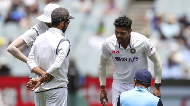 India's Umesh Yadav, top right, receives treatment during play on day three of the second cricket test between India and Australia at the Melbourne Cricket Ground, Melbourne, Australia, Monday, Dec. 28, 2020.(AP)