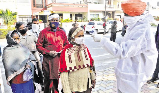 An official scanning the temperature of voters outside Government Model Primary School at Sector-16 in Panchkula on Sunday. (Keshav Singh/HT) An official scanning the temperature of voters outside Government Model Primary School at Sector-16 in Panchkula on Sunday. (Keshav Singh/HT)