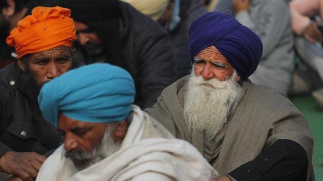 Indian farmers listen to a speech of their leader at a gathering in protest against new farm laws at the Delhi-Haryana state border, on the outskirts of New Delhi, India.(AP)