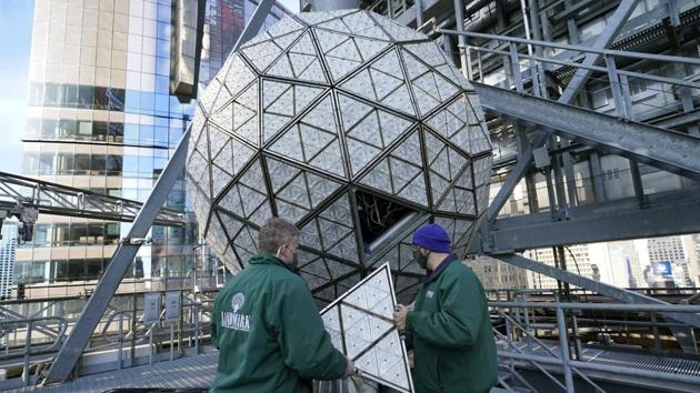 Workers from Landmark Signs carefully carry a panel of Waterford crystal triangles to place onto the Times Square New Year's Eve ball, Sunday, Dec. 27, 2020, in New York, in preparation for this year's pandemic-limited celebration.(AP)