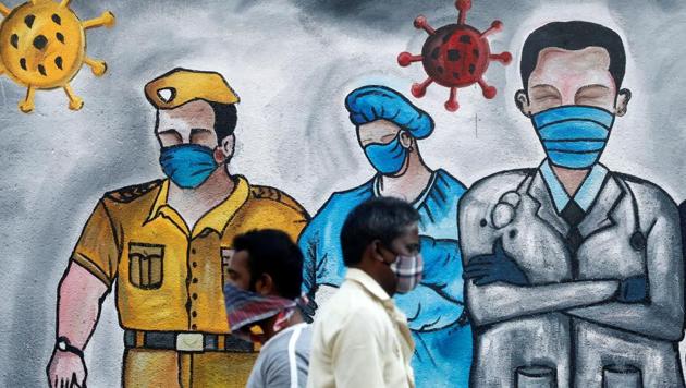 Men walk past a mural of frontline workers amid the spread of the coronavirus disease in Mumbai, India. (REUTERS) Men walk past a mural of frontline workers amid the spread of the coronavirus disease in Mumbai, India. (REUTERS)