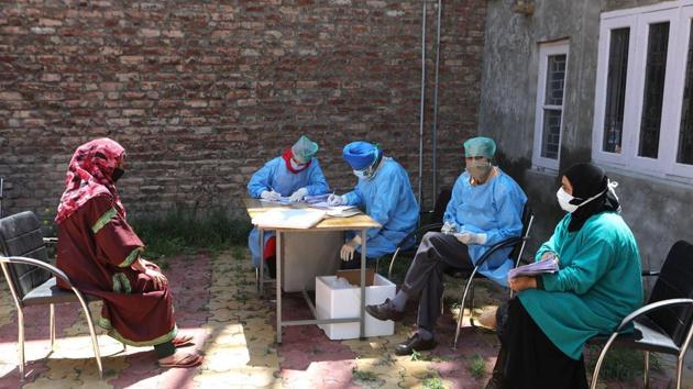 Medical workers take note of a woman’s health history at a coronavirus testing centre in Srinagar.(HT FILE PHOTO)