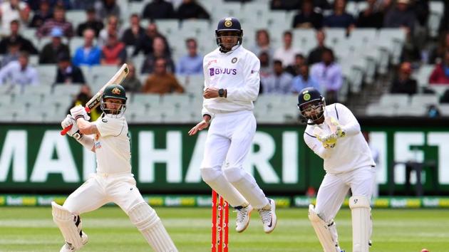 Australia's Matthew Wade (L) plays a shot as India's Shubman Gill (C) jumps in the air to avoid a direct hit on the third day of the second cricket Test match between Australia and India at the MCG in Melbourne.(AFP)