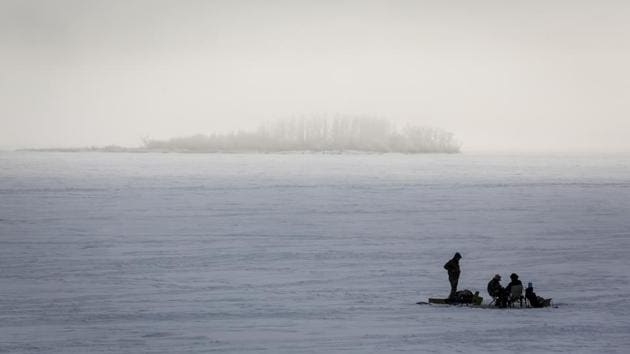Ice fishermen huddle over a hole in the ice on Ghost Lake Reservoir near Cochrane, Alberta, Canada on December 27. After Europe, the US and Canada make up the second worst-hit Covid-19 region. (Jeff McIntosh/The Canadian Press via AP) Ice fishermen huddle over a hole in the ice on Ghost Lake Reservoir near Cochrane, Alberta, Canada on December 27. After Europe, the US and Canada make up the second worst-hit Covid-19 region. (Jeff McIntosh/The Canadian Press via AP)