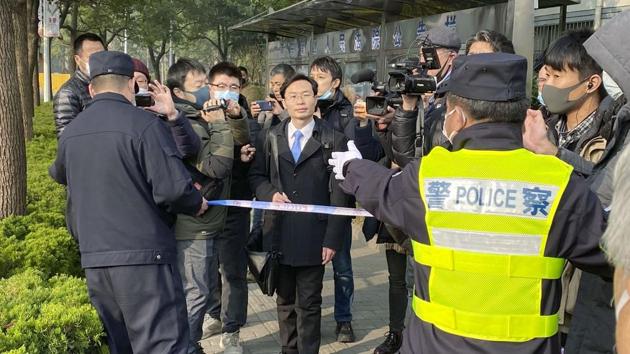 A police officer tries to stop media as a lawyer, center, of Zhang Zhan arrives at a court in Shanghai, China. (AP) A police officer tries to stop media as a lawyer, center, of Zhang Zhan arrives at a court in Shanghai, China. (AP)
