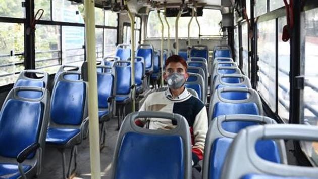 A man wearing a face mask seen sitting in an empty DTC bus, as people avoid crowded places, in view of Coronavirus (Covid-19) concerns, in New Delhi.(Vipin Kumar/HT PHOTO)