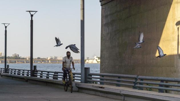 A cyclist wears a protective mask while riding along a near-empty Sabarmati Riverfront in Ahmedabad.(Bloomberg)