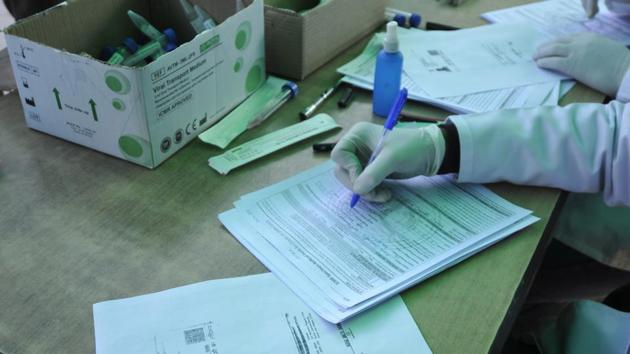 A health worker registers people for coronavirus test, at Sector 30 District Hospital, in Noida, India, on Monday, December 28, 2020. (Photo by Sunil Ghosh / Hindustan Times)