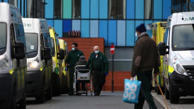 Paramedics wheel a patient into The Royal London Hospital on December 27 in London. Health trusts have been told to begin planning for the use of Nightingale field hospitals, the temporary facilities created during the first wave that have largely gone unused. (Hollie Adams / Getty Images) 