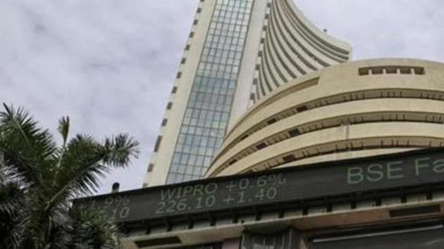 A pedestrian wearing a protective mask walks past the Bombay Stock Exchange (BSE) building in Mumbai.(Bloomberg) A pedestrian wearing a protective mask walks past the Bombay Stock Exchange (BSE) building in Mumbai.(Bloomberg)