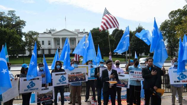 Uyghurs of the East Turkistan National Awakening Movement (ETNAM) listen to their national anthem as they hold a rally to protest the 71st anniversary of the People's Republic of China in front of the White House in Washington, DC.(AFP)