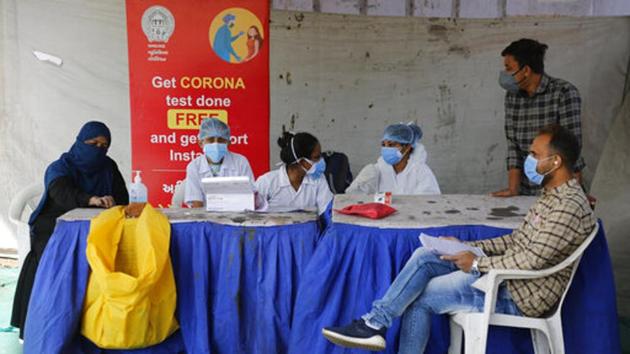 Health workers wait for people at a testing facility for Covid-19 in Ahmedabad on December 28. The government is carrying out vaccination dry run to prepare the infrastructure before the expected roll-out of Covid-19 vaccine in January. The dry run will also help health authorities identify the shortcomings and sort out the issues before vaccines are administered to people. (Ajit Solanki / AP) Health workers wait for people at a testing facility for Covid-19 in Ahmedabad on December 28. The government is carrying out vaccination dry run to prepare the infrastructure before the expected roll-out of Covid-19 vaccine in January. The dry run will also help health authorities identify the shortcomings and sort out the issues before vaccines are administered to people. (Ajit Solanki / AP)