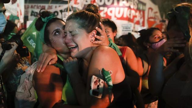 Abortion-rights activists react after lawmakers approved a bill that legalizes abortion, outside Congress in Buenos Aires, Argentina.(AP)