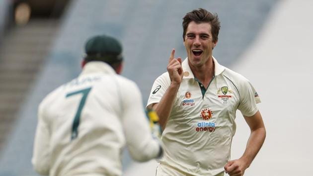 Australia's Pat Cummins celebrates with teammate Tim Paine after taking the wicket of India's Cheteshwar Pujara during play on day two of the second cricket test between India and Australia at the Melbourne Cricket Ground.(AP)