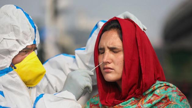 A health worker collects a nasal sample from a woman for Covid-19 test in Jammu.(PTI)