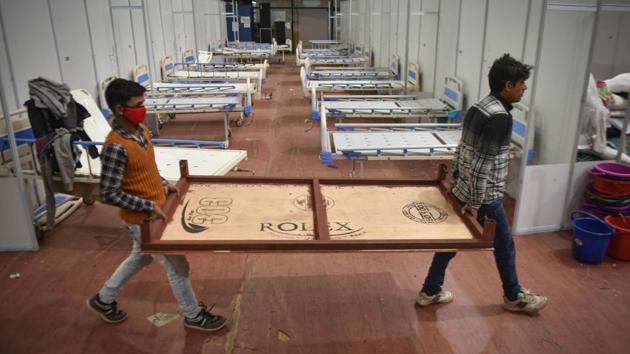 Workers dismantling beds at the Commonwealth Games Village (CWG) Covid Care Centre that has been closed as part of de-escalation of facilities in New Delhi on December 29. The total active cases have dropped to 262,272 and the recovery rate is nearing 96% with over 9.83 million people discharged or cured until now. (Sanchit Khanna / HT Photo) Workers dismantling beds at the Commonwealth Games Village (CWG) Covid Care Centre that has been closed as part of de-escalation of facilities in New Delhi on December 29. The total active cases have dropped to 262,272 and the recovery rate is nearing 96% with over 9.83 million people discharged or cured until now. (Sanchit Khanna / HT Photo)