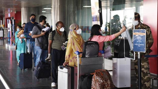 Travellers show their IDs while maintaining social distancing at an entry gate at Terminal T2 of Indira Gandhi International (IGI) Airport which resumes operations from today in New Delhi.(Vipin Kumar/HT PHOTO)