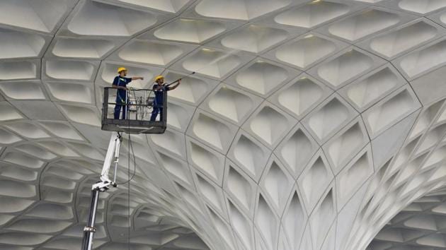 Workers clean the exterior wall roof of Terminal 2 of the Chhatrapati Shivaji International Airport, operated by GVK Power & Infrastructure Ltd at Andheri in Mumbai. (Satyabrata Tripathy/HT Photo) Workers clean the exterior wall roof of Terminal 2 of the Chhatrapati Shivaji International Airport, operated by GVK Power & Infrastructure Ltd at Andheri in Mumbai. (Satyabrata Tripathy/HT Photo)