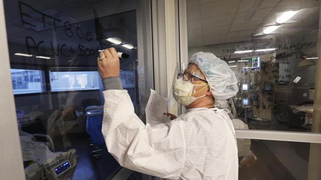 A doctor writes respiratory settings for a patient in the Covid-19 intensive care unit in California hospital, on December 29. (AP Photo) A doctor writes respiratory settings for a patient in the Covid-19 intensive care unit in California hospital, on December 29. (AP Photo)