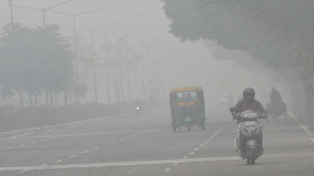 Commuters on their way during foggy weather in Delhi.(Photo by Keshav Singh/Hindustan Times)