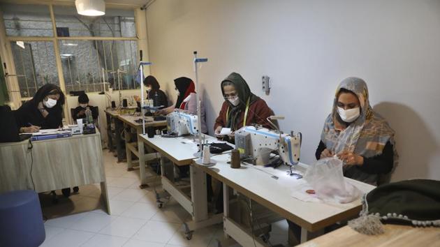 Women sew protective face masks at a workshop of Bavar charity in Tehran, Iran.(AP)