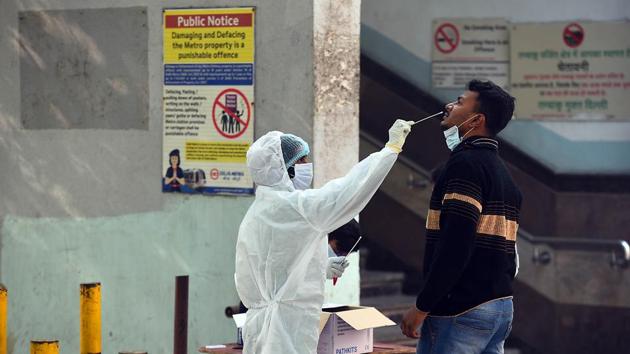 A health worker in PPE collects a swab sample from a person for coronavirus testing, outside New Ashok Nagar Metro station in New Delhi, India.(Raj K Raj/HT PHOTO) A health worker in PPE collects a swab sample from a person for coronavirus testing, outside New Ashok Nagar Metro station in New Delhi, India.(Raj K Raj/HT PHOTO)