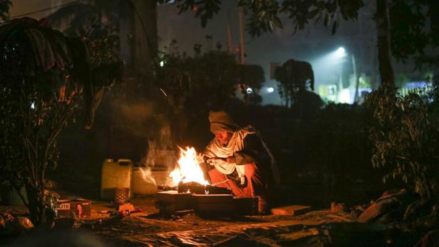 A man warms himself next to a bonfire at Pusa Road in New Delhi on December 31. Delhi recorded the season’s lowest temperature at 1.1 degrees Celsius on January 1, according to Regional Meteorological Centre. There was very dense fog in Palam with 0 visibility till 7am. After 7am, visibility improved to around 150 metres, HT reported. (Sanchit Khanna / HT Photo)