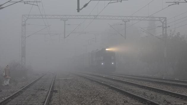 A locomotive passes by Medicare Chowk at Laxman Vihar amid dense fog, in Gurugram on December 31. Hisar and Narnaul in Haryana recorded -1.2°C and 0.5°C respectively on December 31; Bhatinda and Ballowal in Punjab recorded 0°C and 0.2°C respectively. (Parveen Kumar / HT Photo)