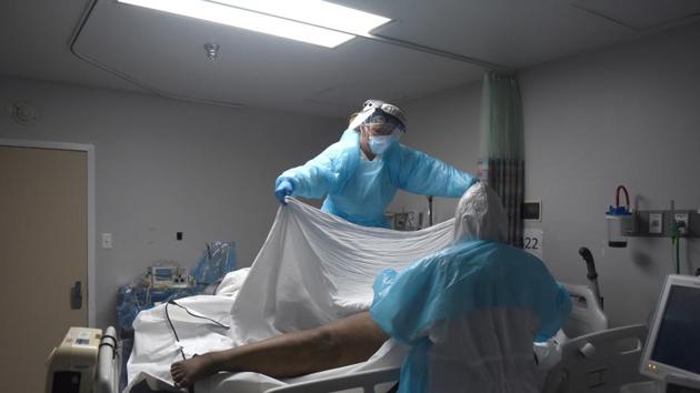 Healthcare workers place the body of a patient who died inside a body bag in the coronavirus disease (Covid-19) unit.(Reuter)