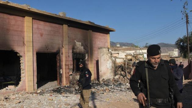 Police officer stand guar in a Hindu temple which was set on fire and demolished by a mob led by Islamists, in Karak, Pakistan. (AP) Police officer stand guar in a Hindu temple which was set on fire and demolished by a mob led by Islamists, in Karak, Pakistan. (AP)