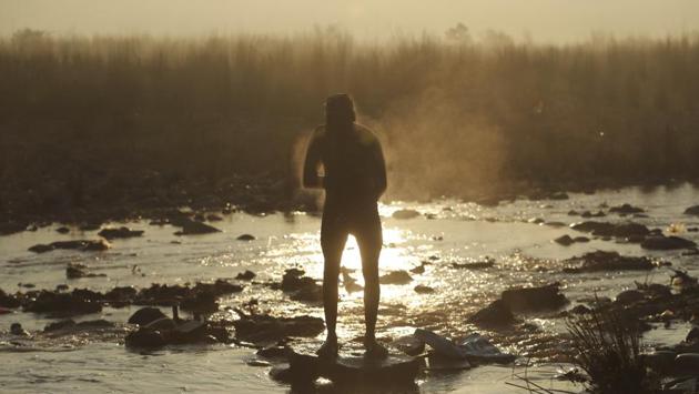 A worker bathes in the Tawi river in the early morning in Jammu on December 31. A fresh active western disturbance likely to affect the western Himalayan region and adjoining plains from January 3 onwards. (Channi Anand / AP)