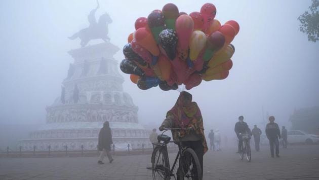 A balloon vendor walks along the Heritage Street amid dense fog, in Amritsar on January 1. Many parts of the northwestern plains have recorded sub-zero or near 0°C minimum temperatures in the last couple of days. (Narinder Nanu / AFP)