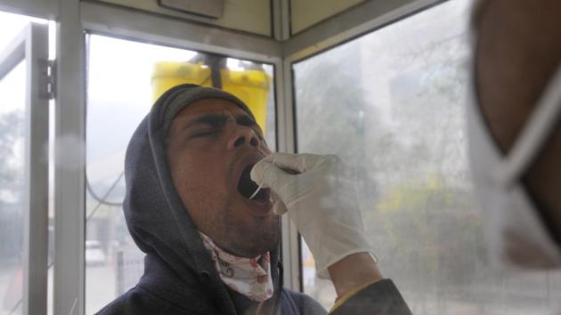 A health worker collects a swab sample from a man for coronavirus screening, at Sector 30 District Hospital, in Noida, India, on Thursday, December 31, 2020. (Photo by Sunil Ghosh / Hindustan Times) A health worker collects a swab sample from a man for coronavirus screening, at Sector 30 District Hospital, in Noida, India, on Thursday, December 31, 2020. (Photo by Sunil Ghosh / Hindustan Times)