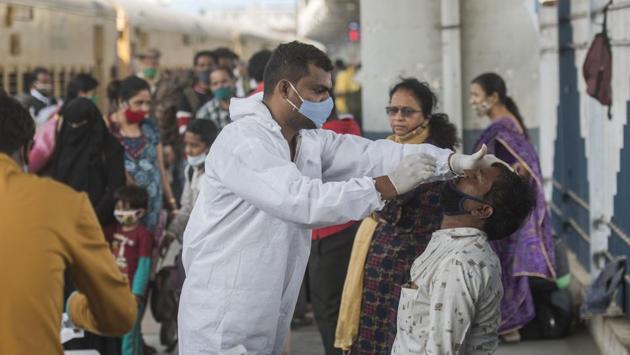 A health worker collects a swab sample from a commuter at Dadar station in Mumbai on January 1. Maharashtra, the worst Covid-19 affected state, reported 3,524 new cases and 59 deaths in the last 24 hours. There are now 52,084 active cases in the state. 1,832,825 people have recovered and the death toll stands at 49,580. (Pratik Chorge / HT Photo)