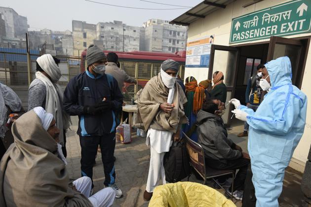 A health worker collects swab samples from passengers for Covid-19 test, New Delhi, January 1, 2020(Biplov Bhuyan/HT PHOTO) A health worker collects swab samples from passengers for Covid-19 test, New Delhi, January 1, 2020(Biplov Bhuyan/HT PHOTO)