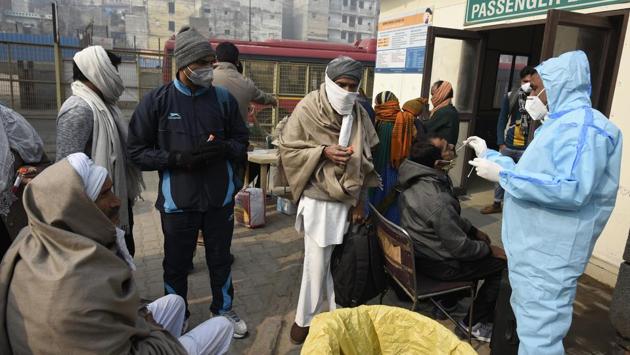 A health worker in PPE coveralls collects a swab sample from travellers for Covid-19 screening before onward journeys at Sarai Kale Khan in New Delhi on January 1. The Indian Council of Medical Research (ICMR) states that 17,39,41,658 samples have been tested in the country for Covid-19 until January 1, including 829,964 on the day itself. (Biplov Bhuyan / HT Photo)