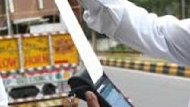 File photo: A traffic police personnel issue a fine.(Arvind Yadav/HT PHOTO) File photo: A traffic police personnel issue a fine.(Arvind Yadav/HT PHOTO)