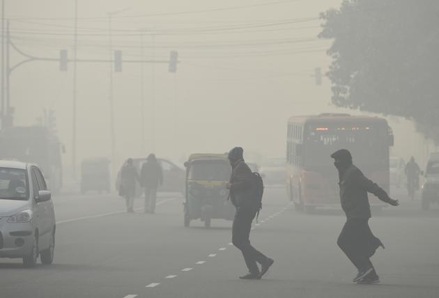 Pedestrians cross a road near Rajpath amid dense fog in New Delhi on Friday. (Biplov Bhuyan/HT PHOTO) Pedestrians cross a road near Rajpath amid dense fog in New Delhi on Friday. (Biplov Bhuyan/HT PHOTO)