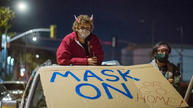 Protesters wearing face masks stand on their vehicle as they participate along with homeless advocates in a protest against a planned public event in spite of the rise of Covid-19 cases in the region, in Los Angeles on December 30. California has emerged as the epicentre for the nation’s latest Covid-19 surge. (Ringo Chiu / AFP) Protesters wearing face masks stand on their vehicle as they participate along with homeless advocates in a protest against a planned public event in spite of the rise of Covid-19 cases in the region, in Los Angeles on December 30. California has emerged as the epicentre for the nation’s latest Covid-19 surge. (Ringo Chiu / AFP)