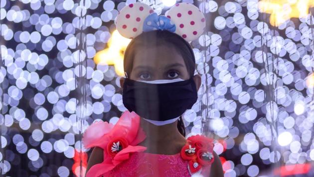 A girl wearing a protective mask looks at decorations at a mall on New Year's Eve, amid the spread of the coronavirus disease (COVID-19) in Mumbai, India.(REUTERS)