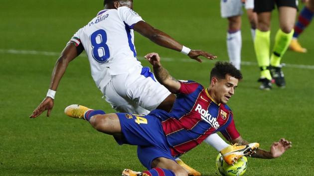 Eibar's Pape Diop, left, challenges Barcelona's Philippe Coutinho during the Spanish La Liga soccer match between Barcelona and Eibar at the Camp Nou stadium in Barcelona in Barcelona, Spain, Tuesday, Dec. 29, 2020.(AP)